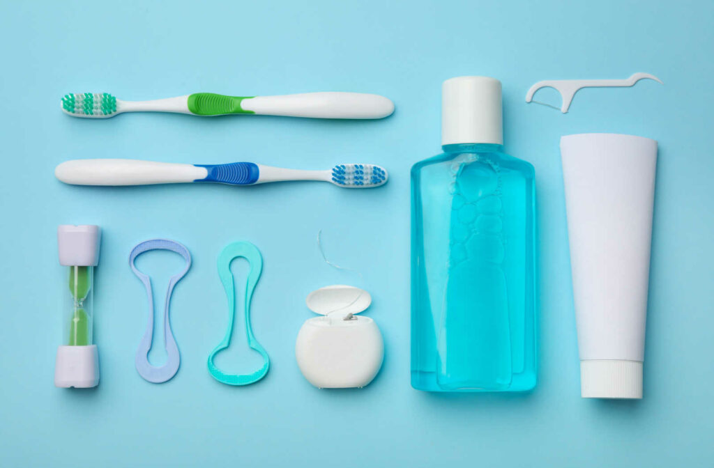 Flat lay composition of a dental hygiene tools on a blue background.