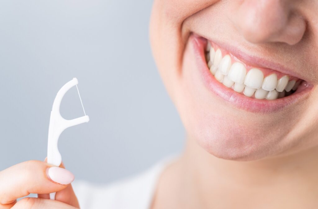 Smiling woman holding dental pick.
