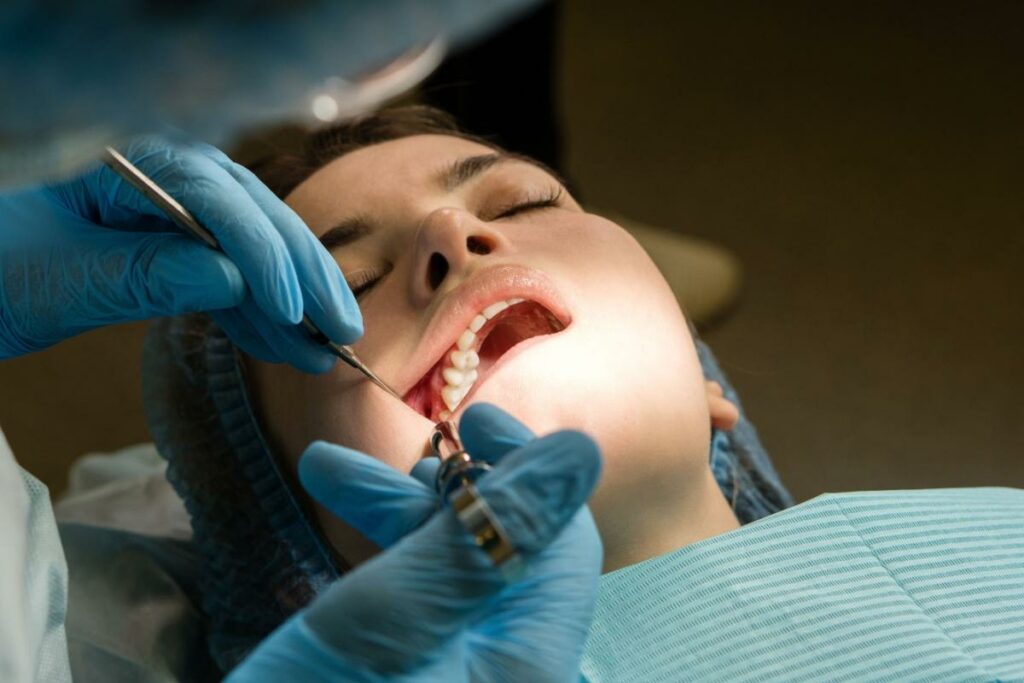 Patient having freezing applied to gums by dentist.